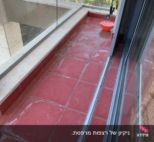 מרפסת עם רצפה אדומה ודלי אדום לניקוי